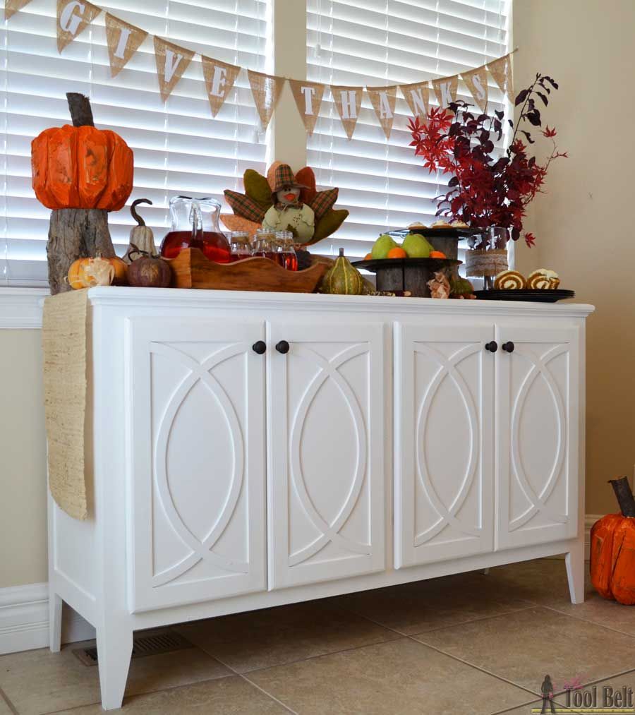 Mesa de buffet blanca con decoraciones de Acción de Gracias